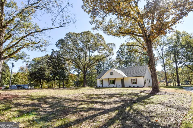 a white house with a large tree in front of it