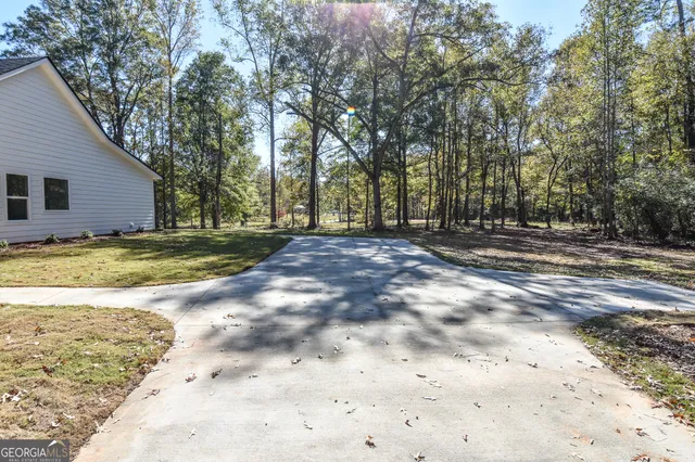 an empty room with wooden floor a ceiling fan and windows
