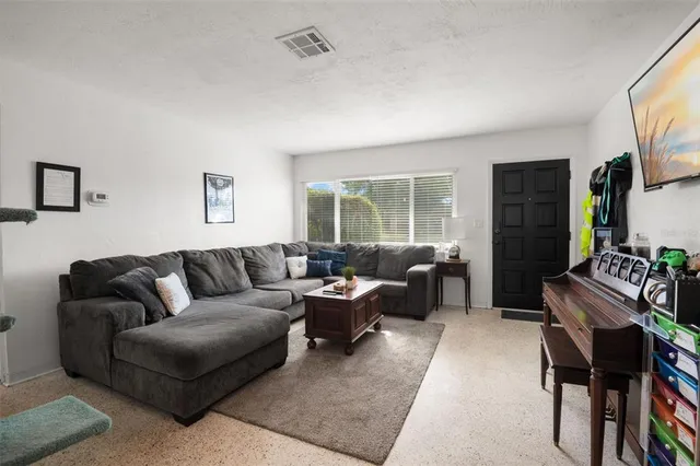 a living room with furniture a flat screen tv and a window