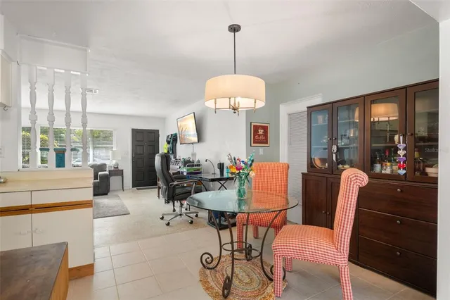 a dining room with furniture a chandelier and wooden floor