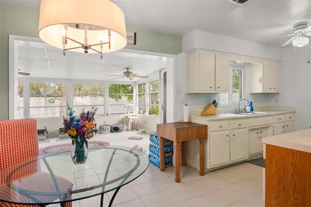 a kitchen with stainless steel appliances granite countertop a sink dishwasher and white cabinets with wooden floor
