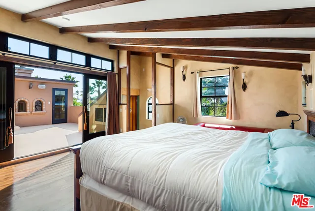 a bedroom with a large bed and a large window