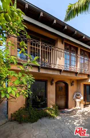 a view of a house with a tree and wooden fence