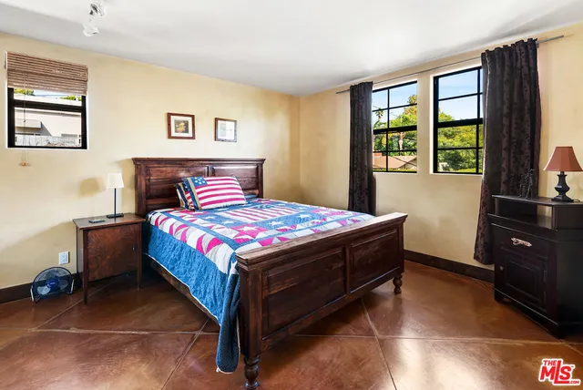 a bed sitting in a bedroom next to a window