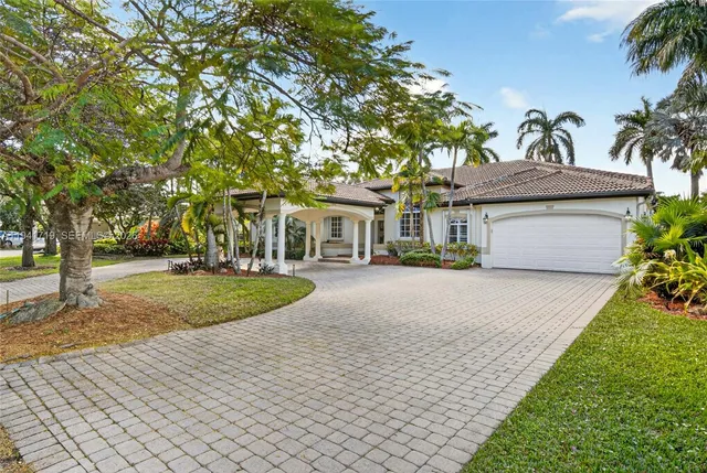 a front view of a house with a yard and potted plants