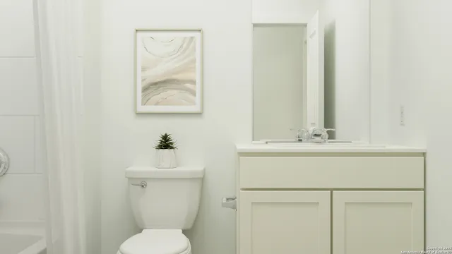 a bathroom with a sink mirror and a toilet