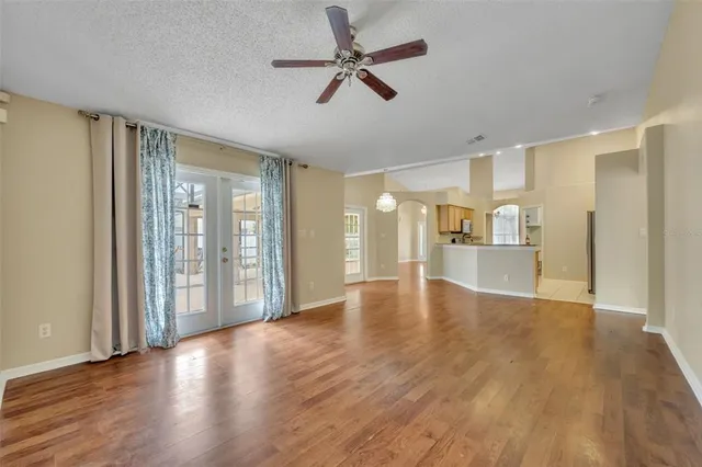 a view of an empty room with a window and wooden floor