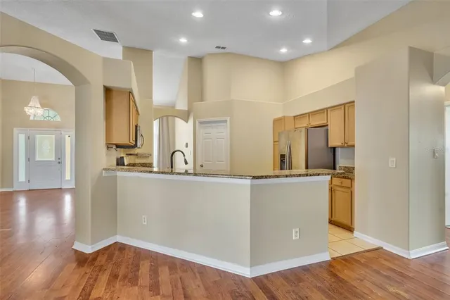 a kitchen with granite countertop a refrigerator and a sink