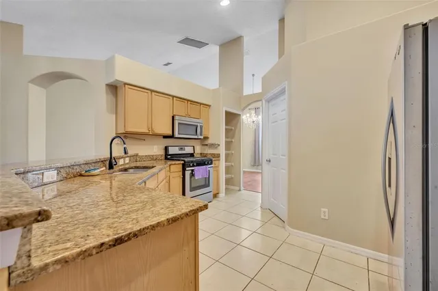 a kitchen with stainless steel appliances granite countertop a refrigerator and a sink