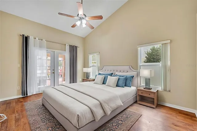 an empty room with wooden floor fan and windows