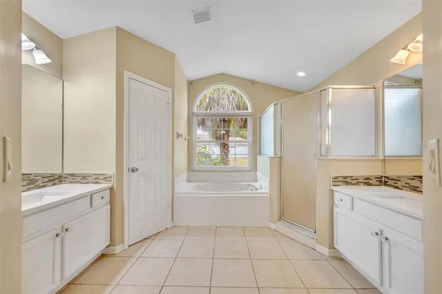 a spacious bathroom with a tub sink and mirror