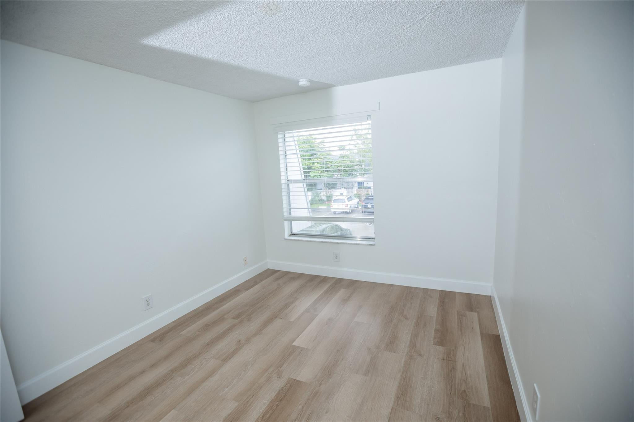 6764 Southwest 40th Street, Unit 40 Davie, FL 33314 - Photo 12 of 17 wooden floor in an empty room with a window