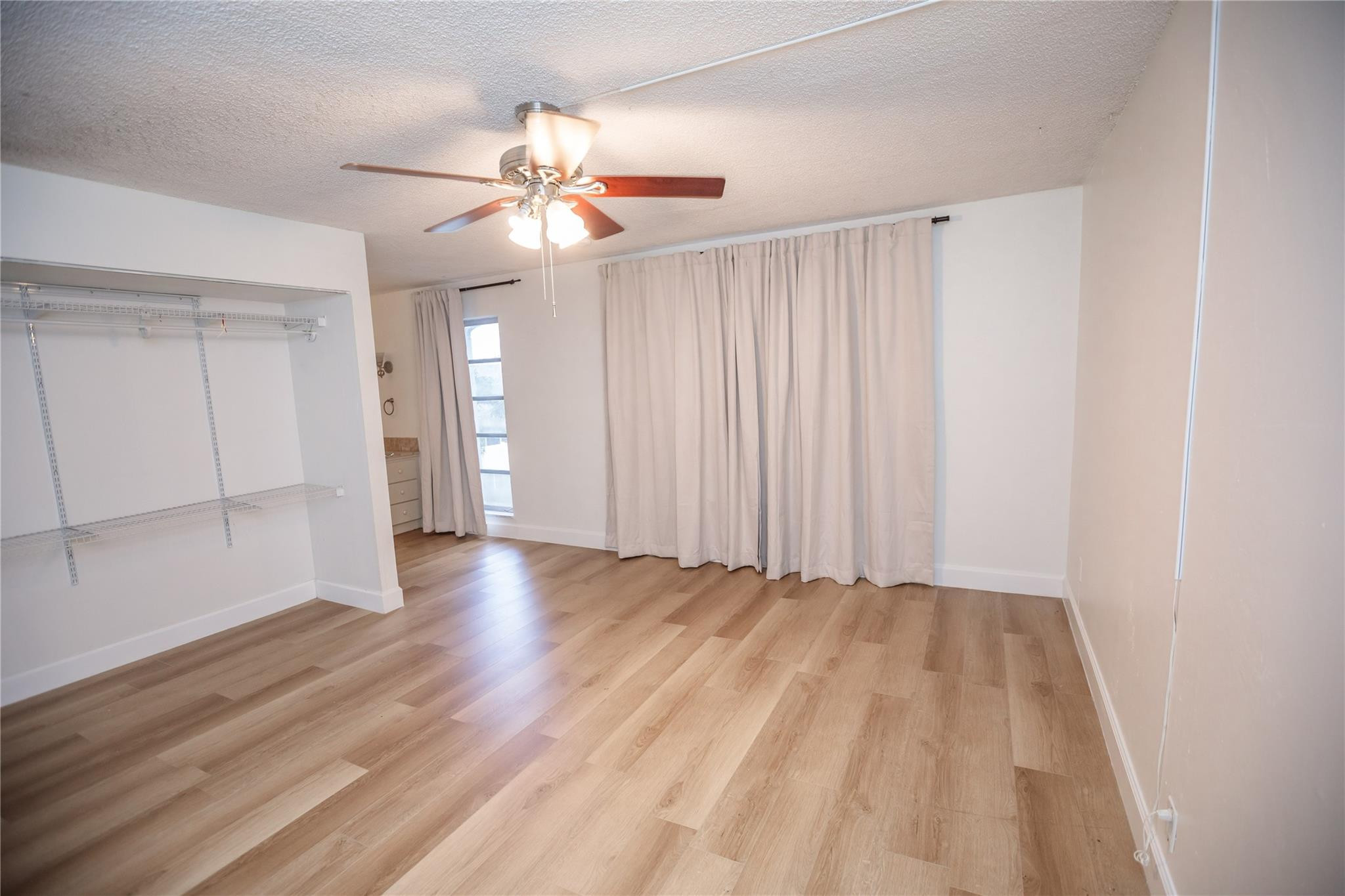 6764 Southwest 40th Street, Unit 40 Davie, FL 33314 - Photo 15 of 17 an empty room with wooden floor fan and windows