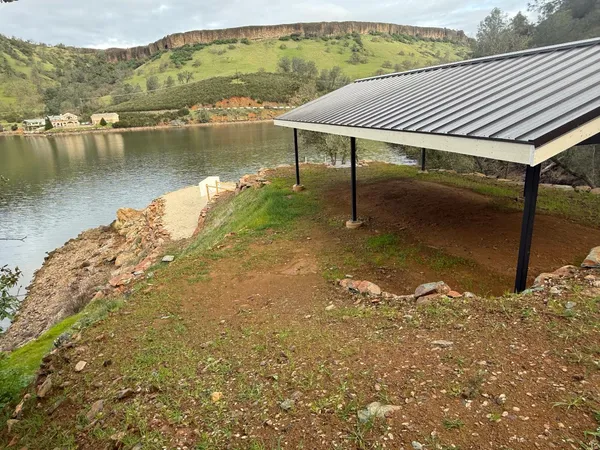 a view of a backyard with a bench and some trees