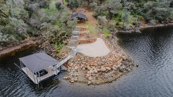 a view of a house with a wooden deck and trees