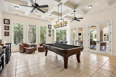 a dining room with furniture a chandelier and glass door