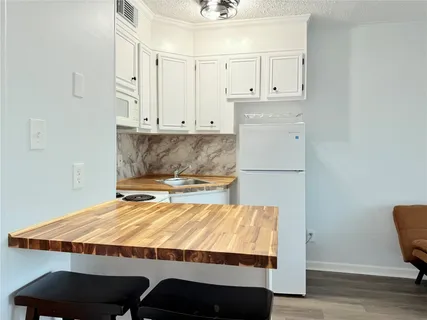 a kitchen with wooden floors and white appliances