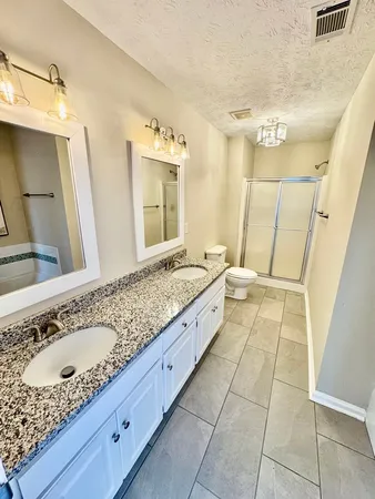 a spacious bathroom with a granite countertop sink and a mirror