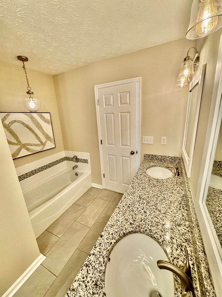 66 Ryan Loop Phenix City, AL 36869 - Photo 20 of 22 a spacious bathroom with a tub sink and mirror
