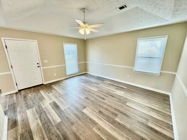 a view of an empty room with wooden floor