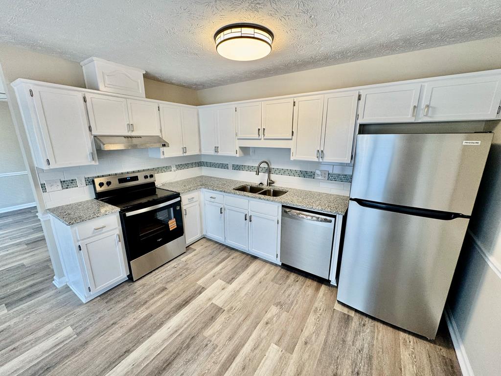 66 Ryan Loop Phenix City, AL 36869 - Photo 7 of 22 a kitchen with stainless steel appliances a refrigerator a stove a sink and white cabinets