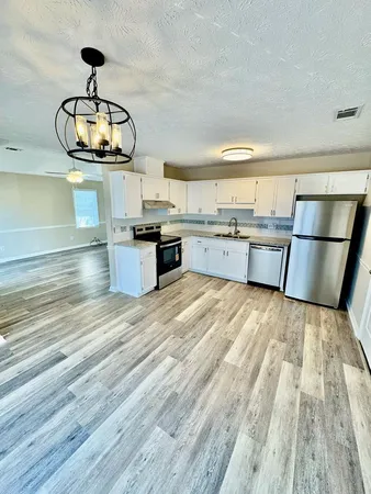 a kitchen with granite countertop a stove and cabinets