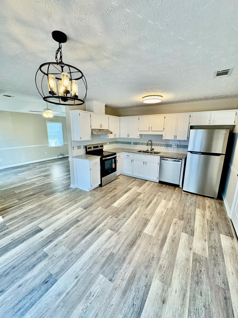 66 Ryan Loop Phenix City, AL 36869 - Photo 8 of 22 a kitchen with granite countertop a stove and cabinets