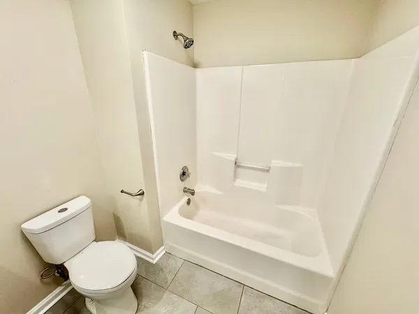 a white toilet sitting next to a bath tub