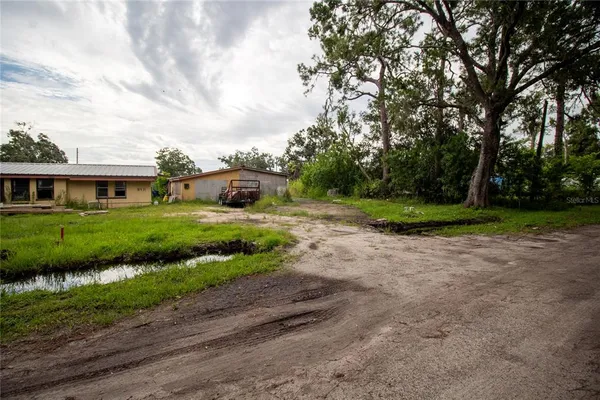a view of a house with backyard and trees
