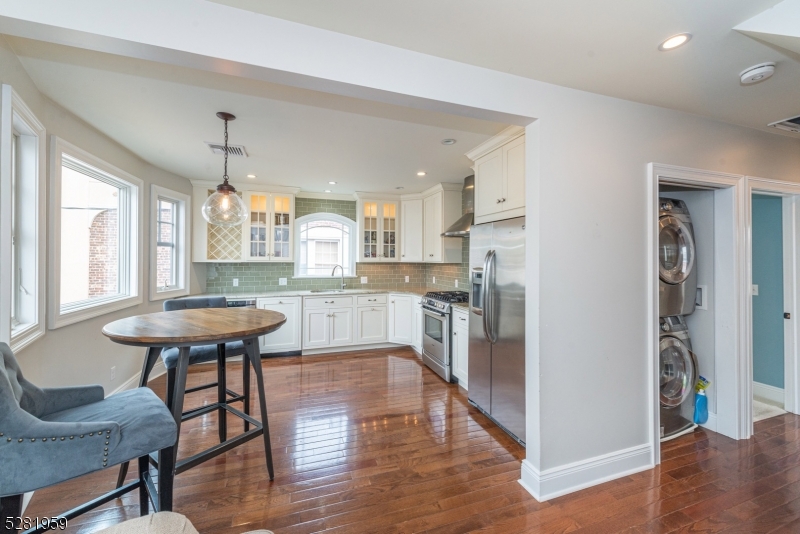 a open kitchen with stainless steel appliances kitchen island a dining table and chairs