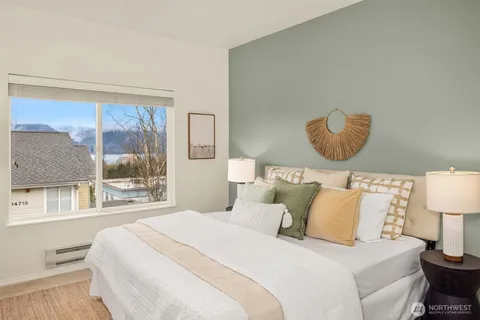 a bedroom with a bed and lamp next to a window