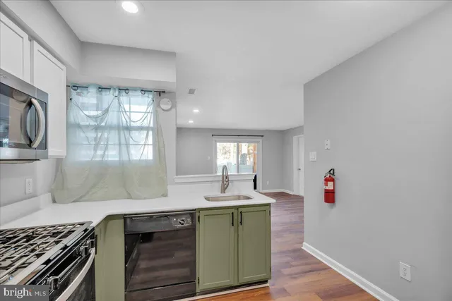 a view of a big room with wooden floor and a kitchen