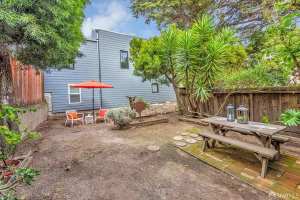 a view of backyard with a table and chairs under an umbrella