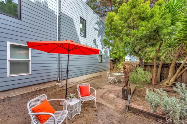 a view of a backyard with table and chairs under an umbrella