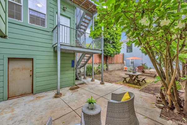 a view of a chair and table in backyard of the house