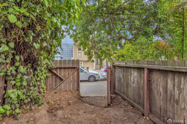 a white bench sitting in backside of a house with wooden fence