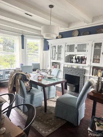 a living room with furniture a fireplace and large windows