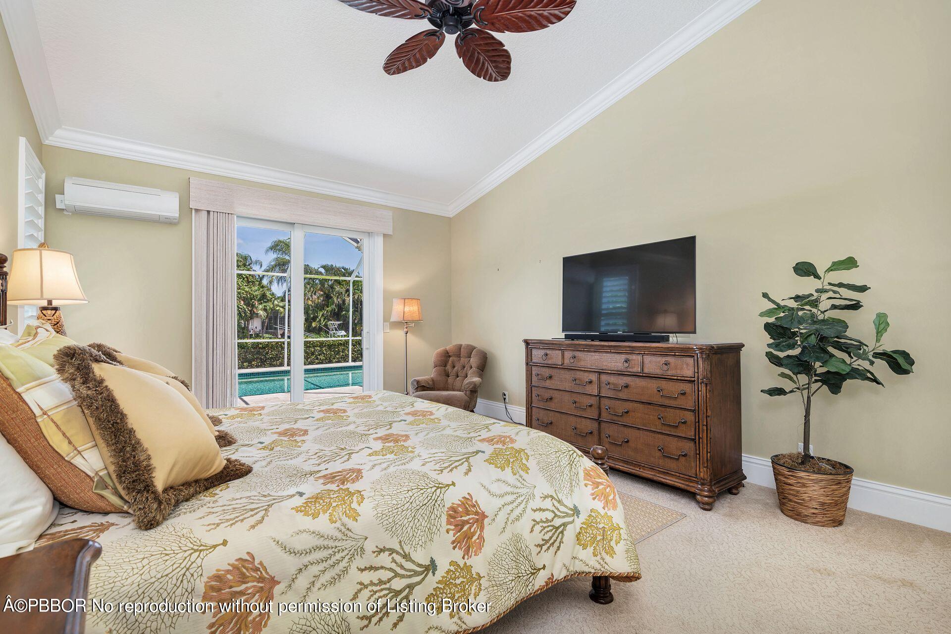 8774 Southeast Riverfront Terrace Tequesta, FL 33469 - Photo 22 of 45 a bedroom with a bed and a flat screen tv