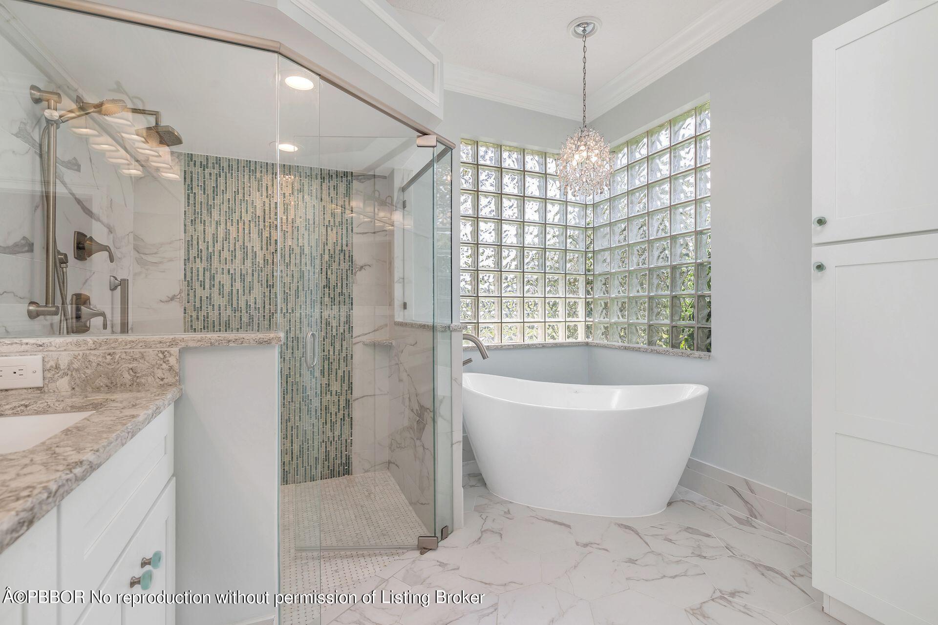 8774 Southeast Riverfront Terrace Tequesta, FL 33469 - Photo 24 of 45 a spacious bathroom with a granite countertop tub sink and shower