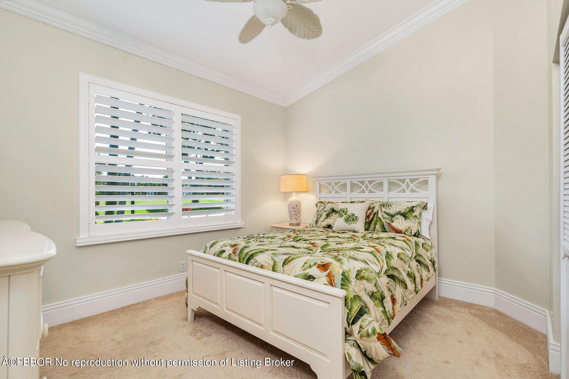 8774 Southeast Riverfront Terrace Tequesta, FL 33469 - Photo 29 of 45 a bed sitting in a bedroom next to a window