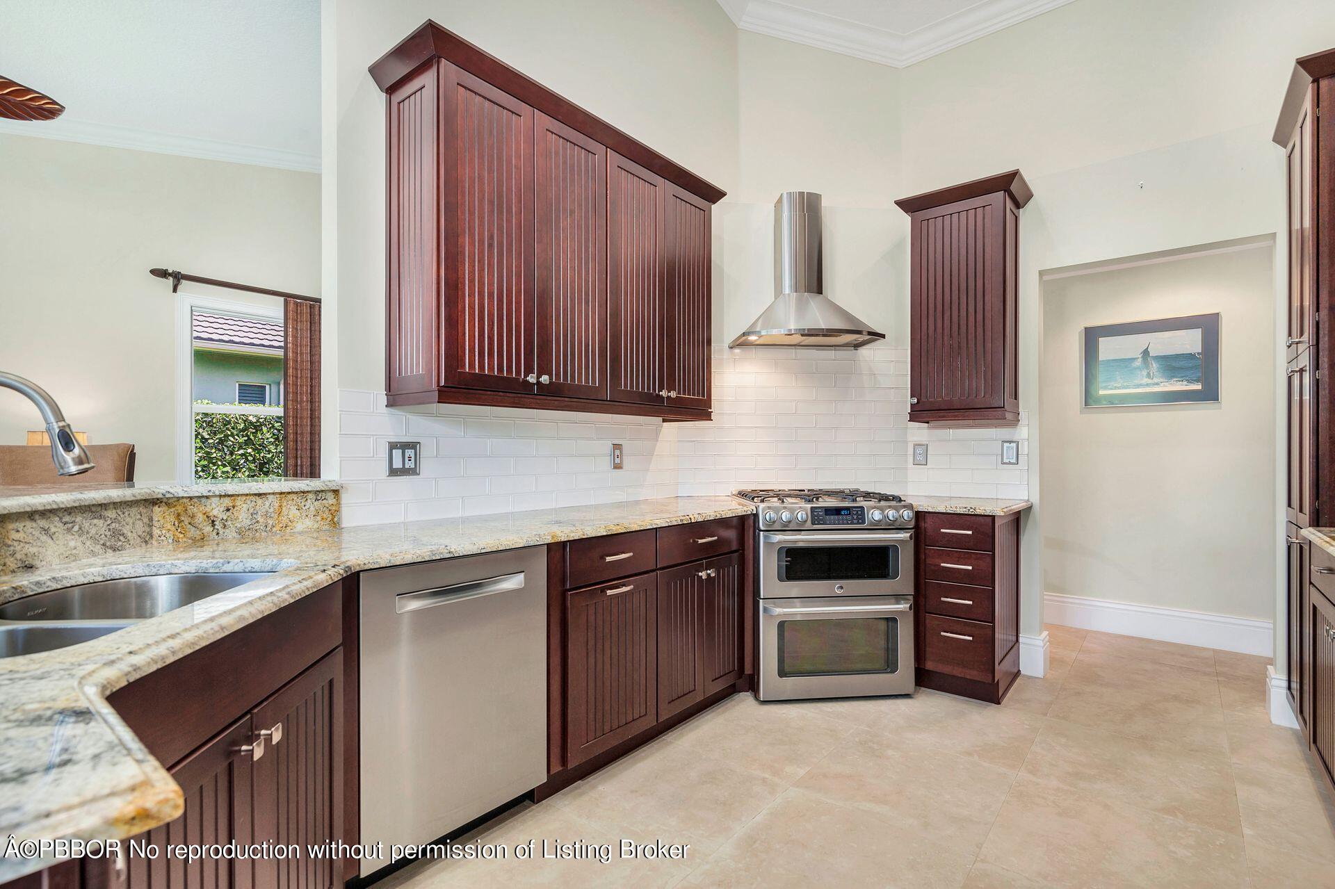 8774 Southeast Riverfront Terrace Tequesta, FL 33469 - Photo 3 of 45 a kitchen with stainless steel appliances granite countertop a stove a sink and a microwave