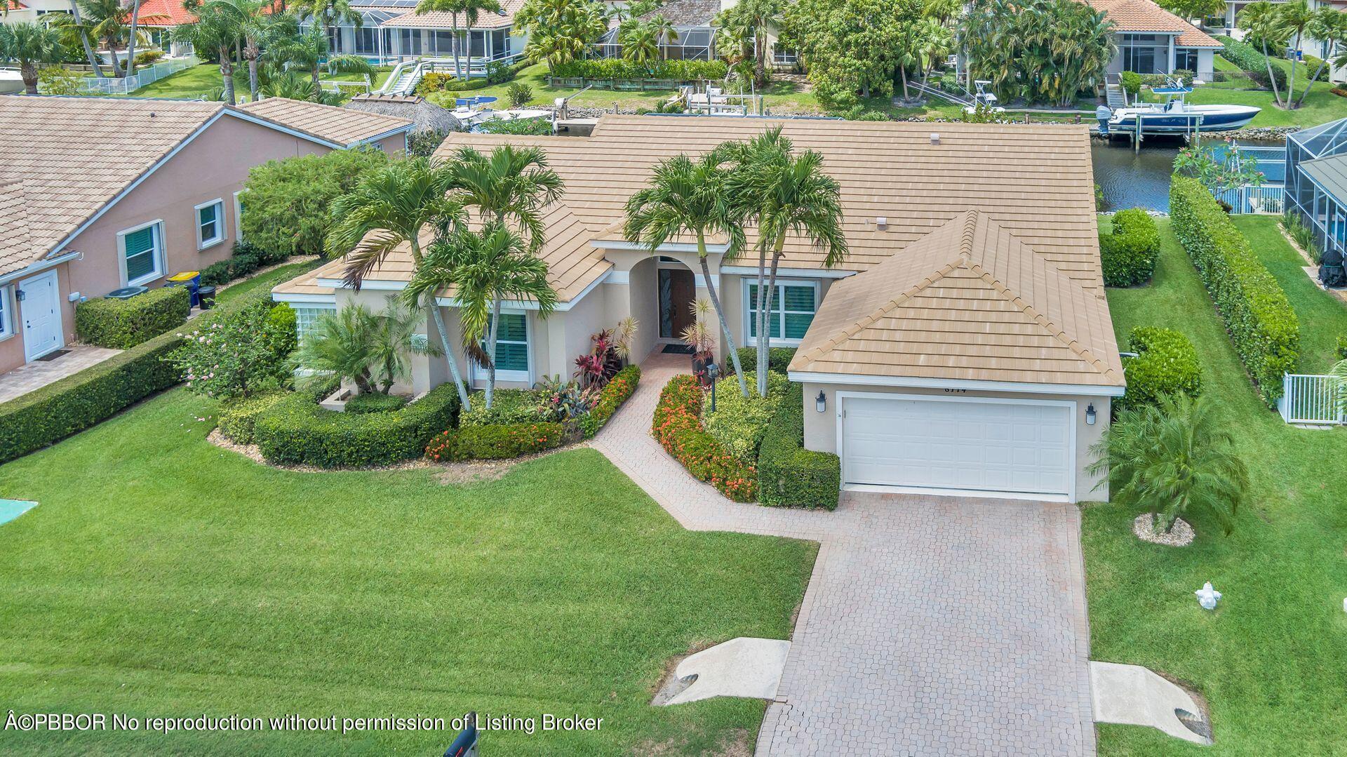 8774 Southeast Riverfront Terrace Tequesta, FL 33469 - Photo 39 of 45 a view of a house with a yard and potted plants
