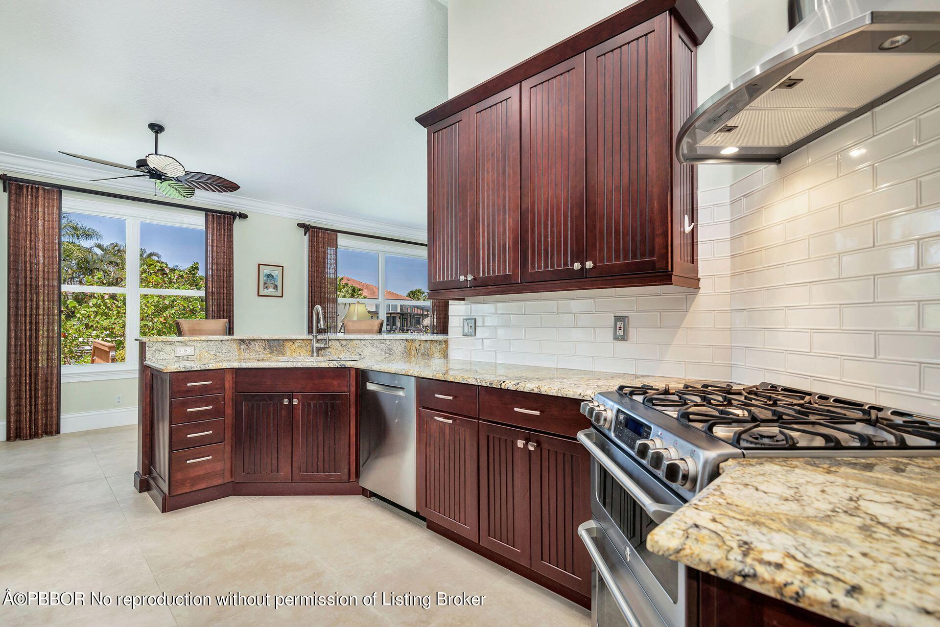 8774 Southeast Riverfront Terrace Tequesta, FL 33469 - Photo 4 of 45 a kitchen with wooden cabinets and stove