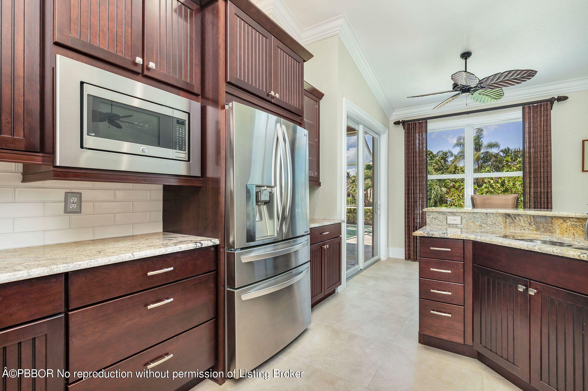 8774 Southeast Riverfront Terrace Tequesta, FL 33469 - Photo 5 of 45 a kitchen with stainless steel appliances granite countertop a refrigerator and a stove top oven