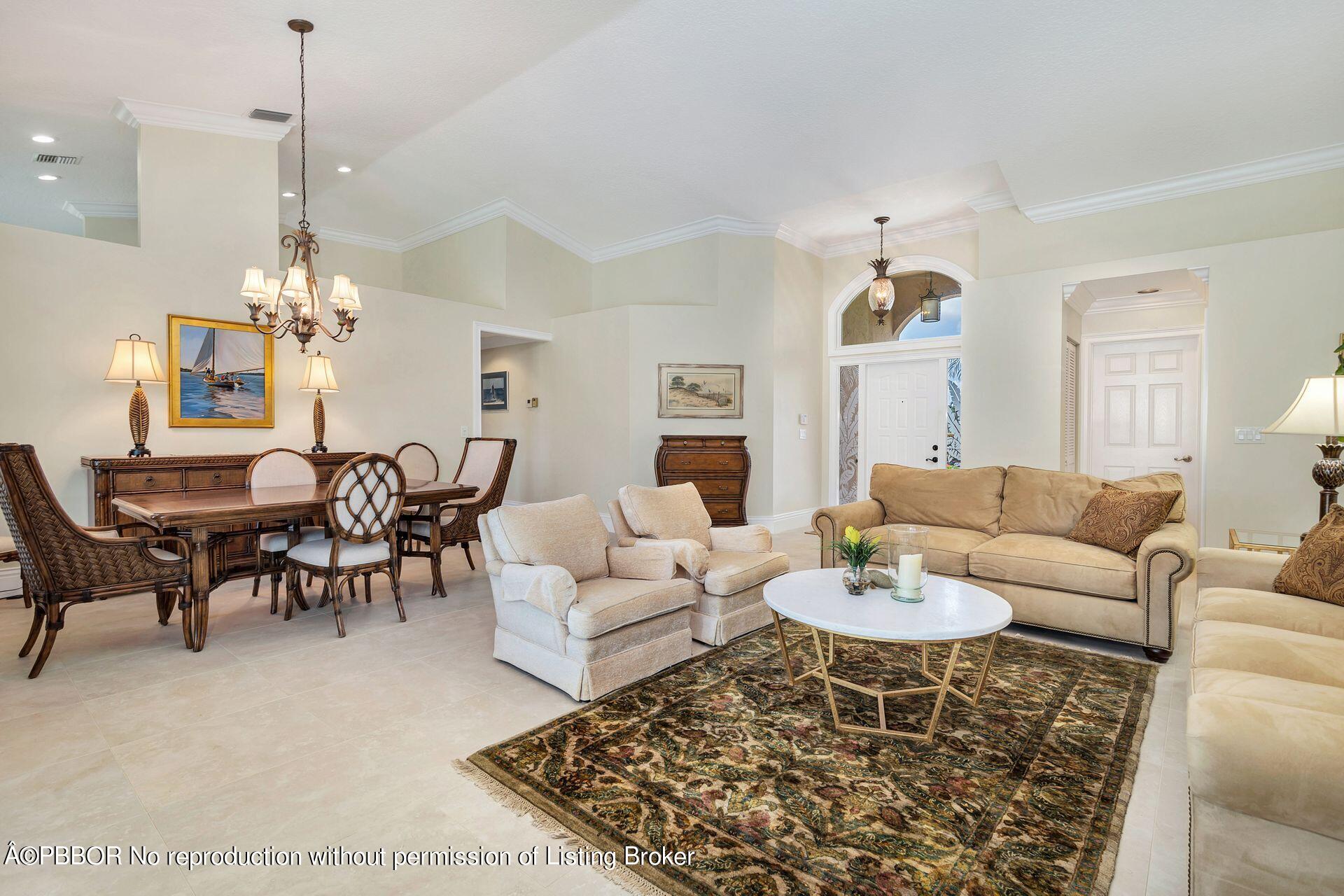 8774 Southeast Riverfront Terrace Tequesta, FL 33469 - Photo 10 of 45 a living room with furniture a dining table and a chandelier