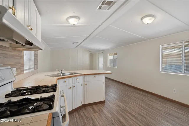 a room with a refrigerator a sink and dishwasher with wooden floor