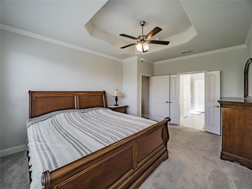 1809 Spinnaker Drive Denton, TX 76210 - Photo 11 of 18 a bedroom with a bed and a chandelier