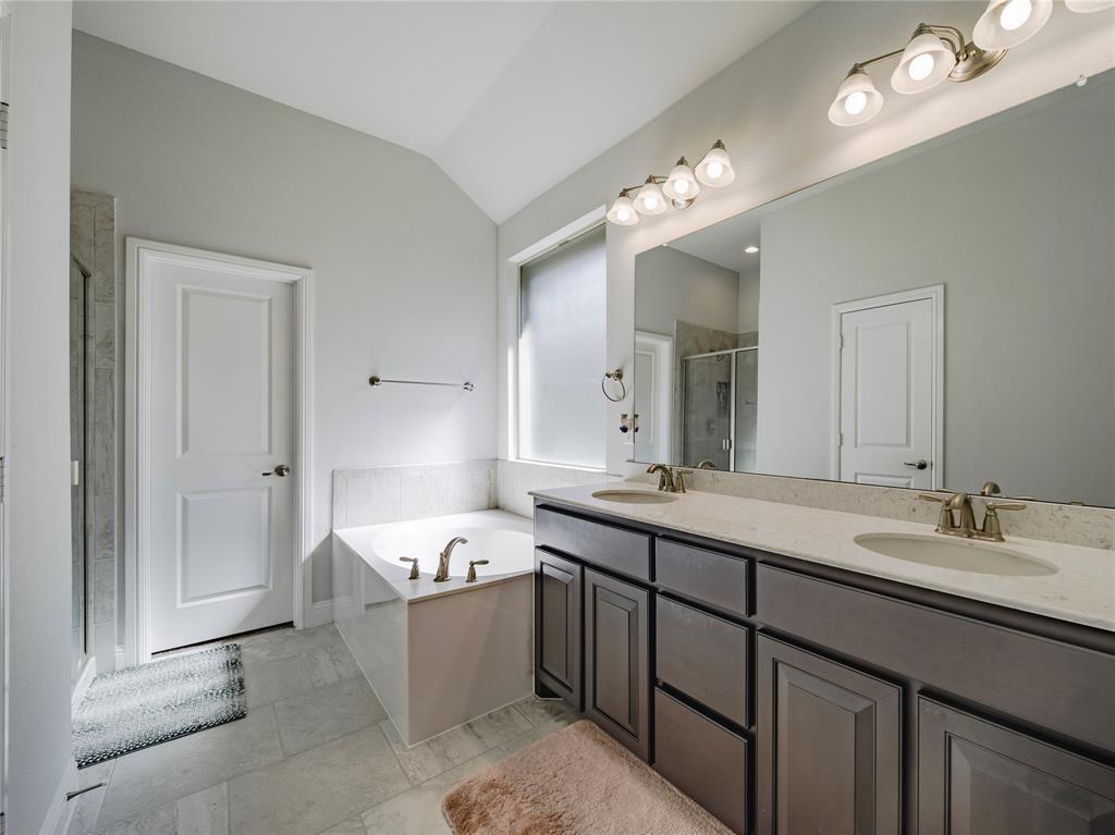 1809 Spinnaker Drive Denton, TX 76210 - Photo 12 of 18 a bathroom with a tub a sink double vanity and a mirror