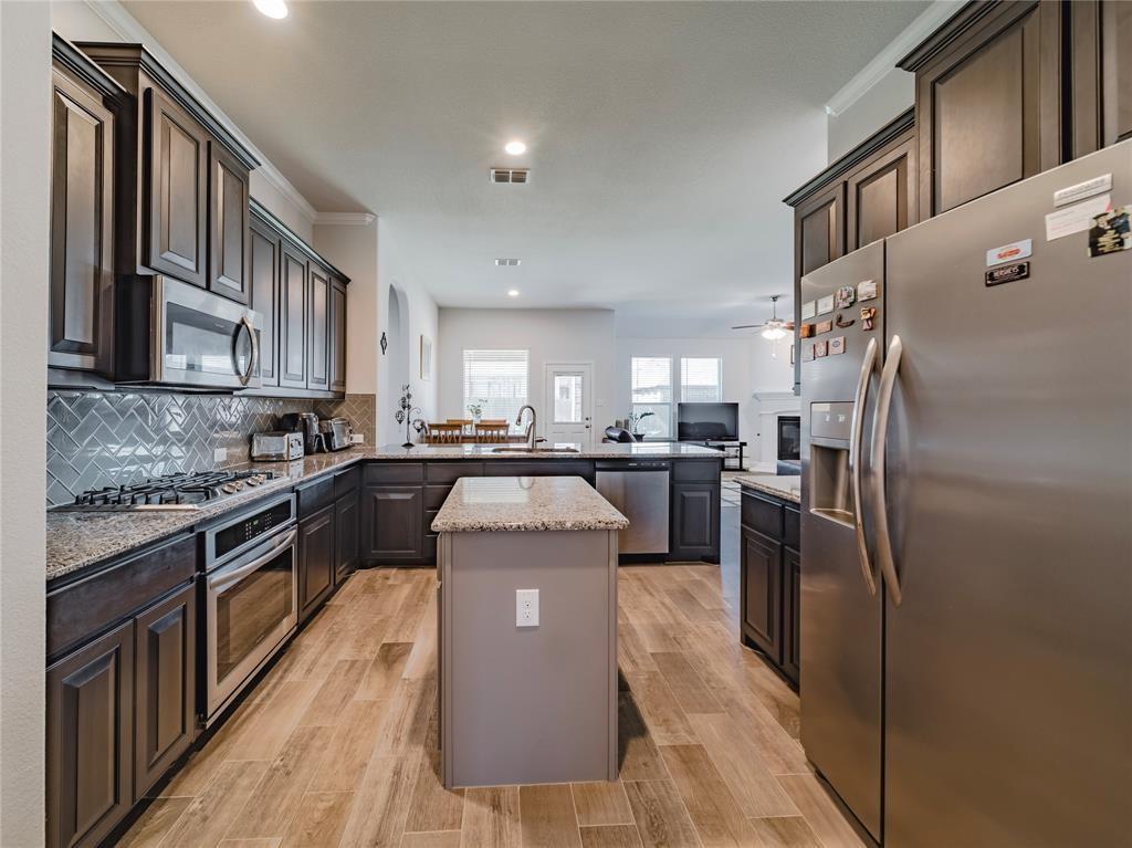 1809 Spinnaker Drive Denton, TX 76210 - Photo 4 of 18 a kitchen with stainless steel appliances granite countertop a refrigerator a stove a sink a washer and dishwasher a oven with wooden cabinets