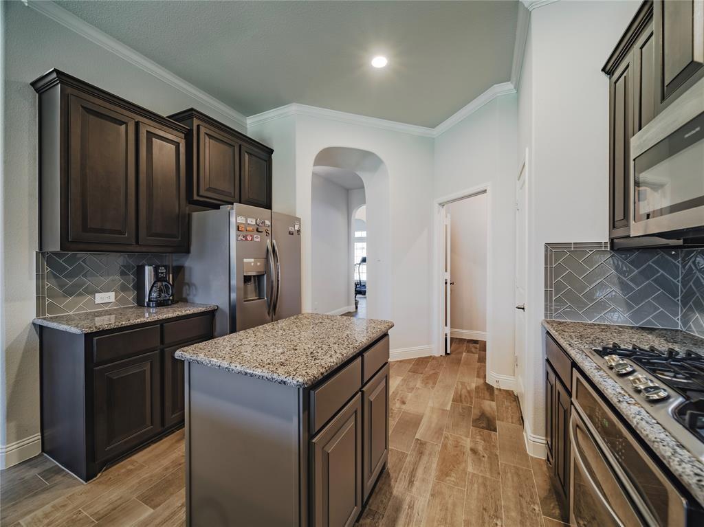1809 Spinnaker Drive Denton, TX 76210 - Photo 5 of 18 a kitchen with granite countertop a sink stove and refrigerator